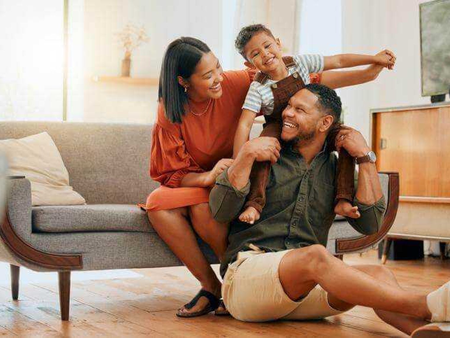 A happy family relaxing in their home and smiling at each other.