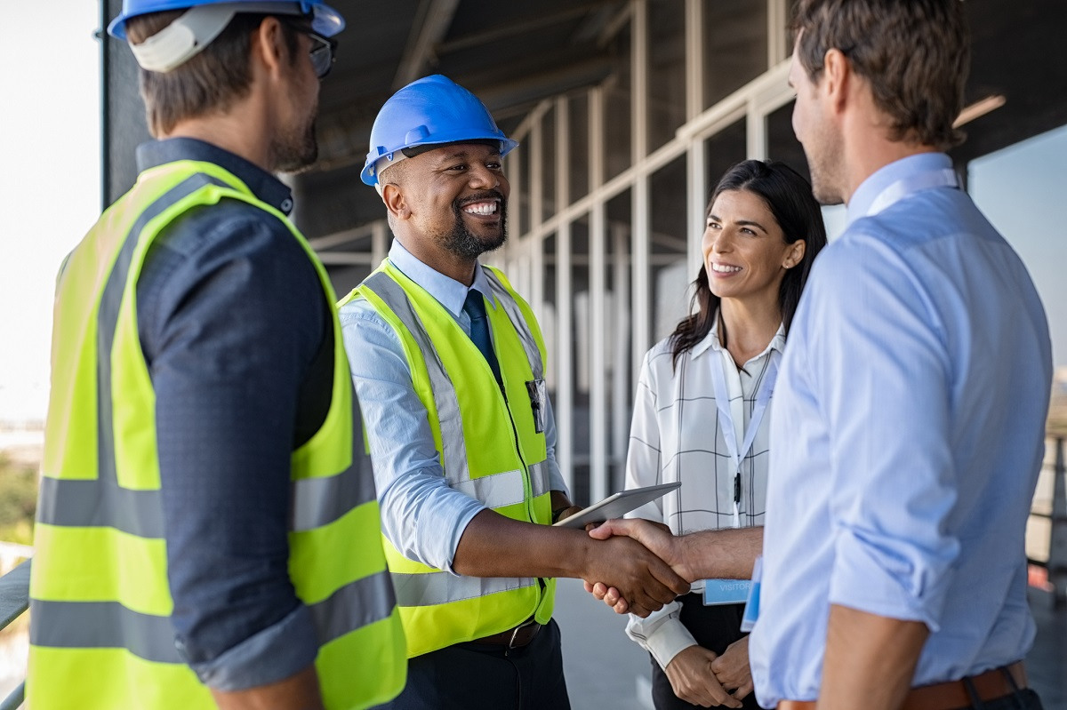 Couple greets contractors on a home construction site.