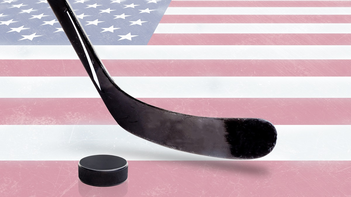 Hockey stick and puck with American flag background.